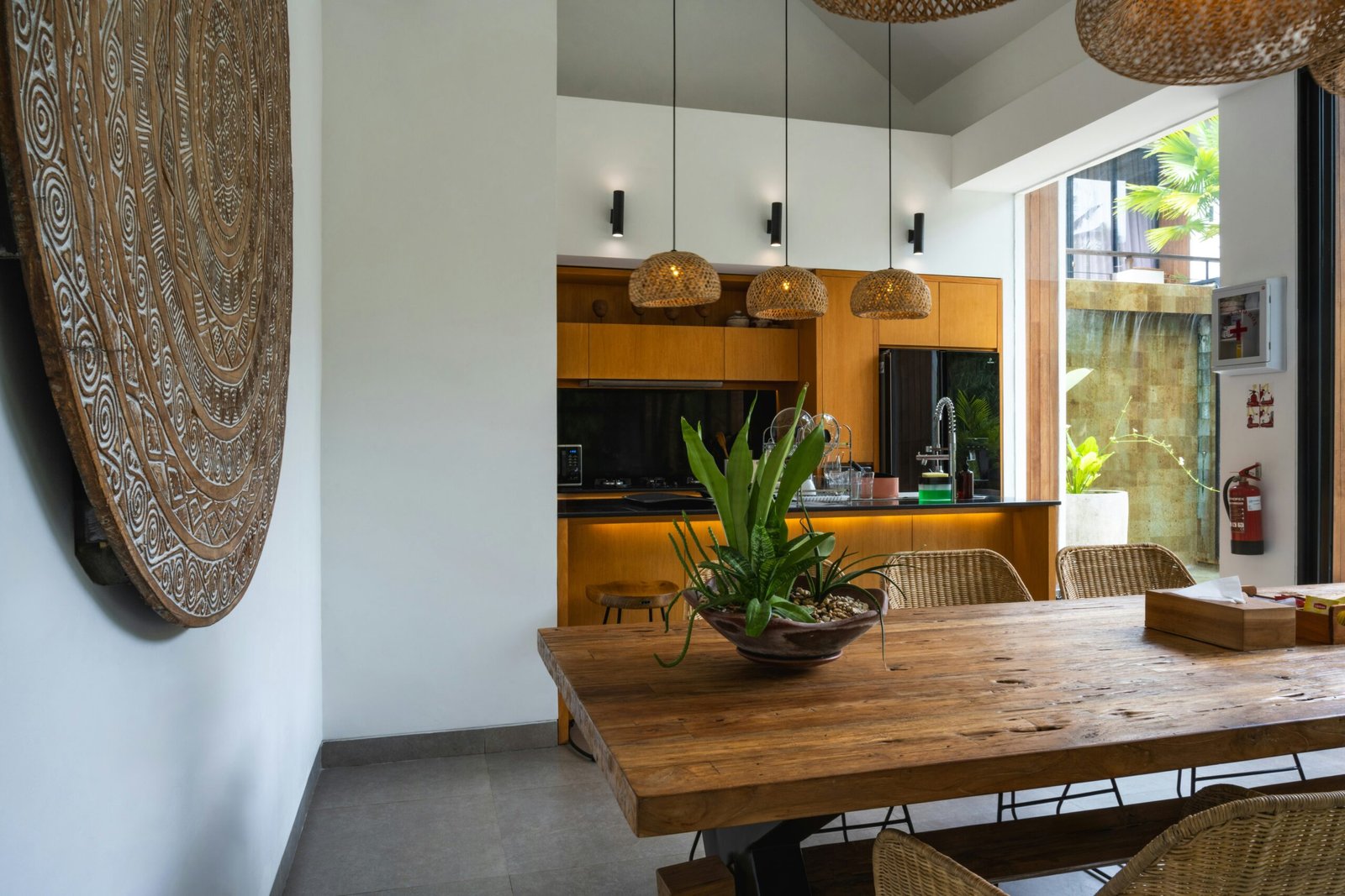 A kitchen with a wooden table surrounded by hanging lights